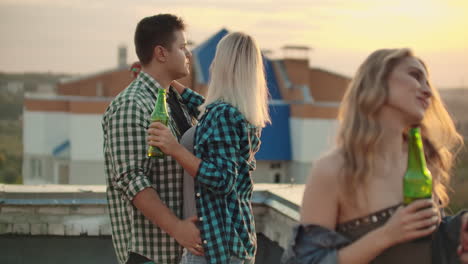 Two-young-couples-dancing-with-their-halves-on-the-roof.-They-enjoy-time-with-beer.